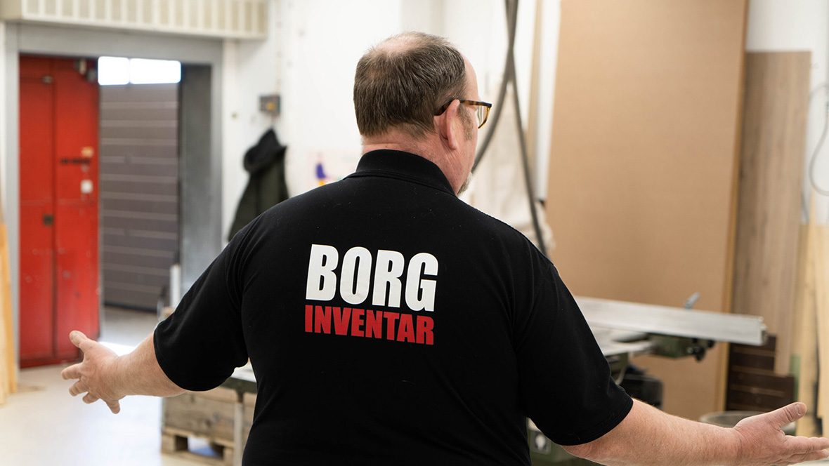 Knud Borg fra Borg Inventar står med ryggen til i virksomhedens værksted